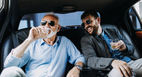 two business people inside luxury car