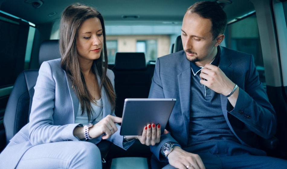 two professionals talking inside luxury car