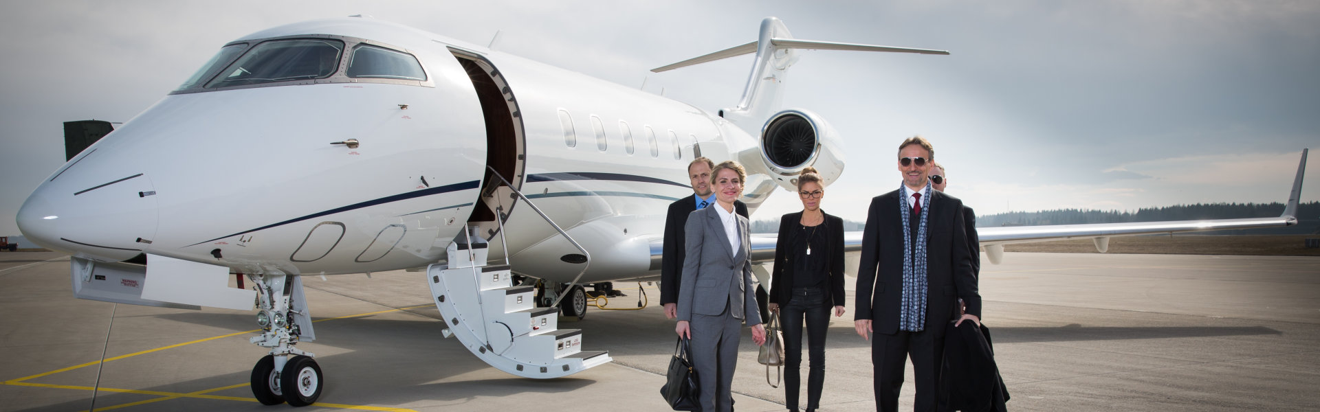 business team with corporate jet in the background