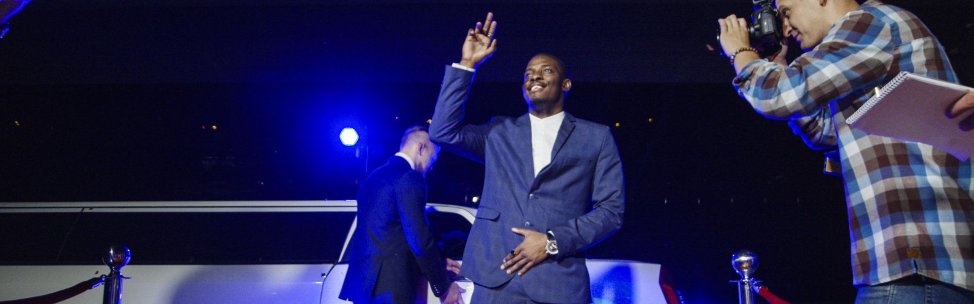 man smiling with limousine in the background