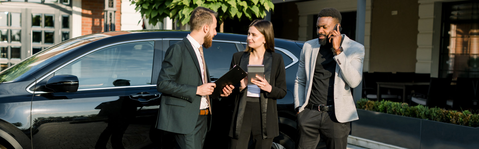 businessmen with black car in the background