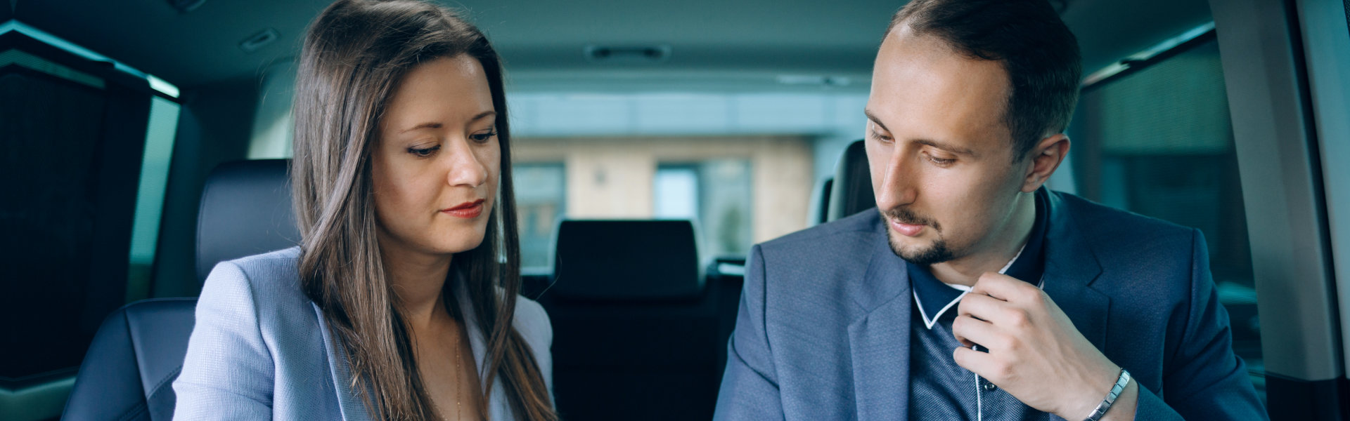 two professionals talking inside luxury car